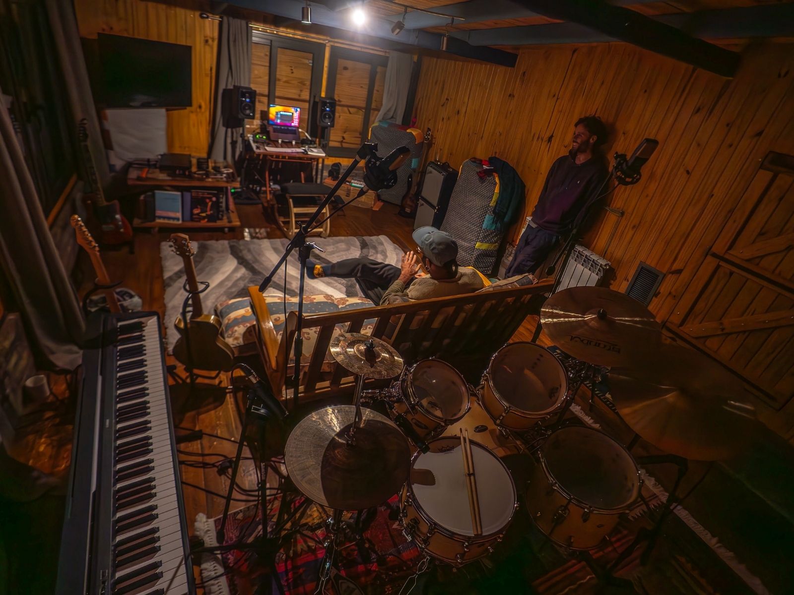 Vista nocturna del estudio desde arriba, piano y batería visibles