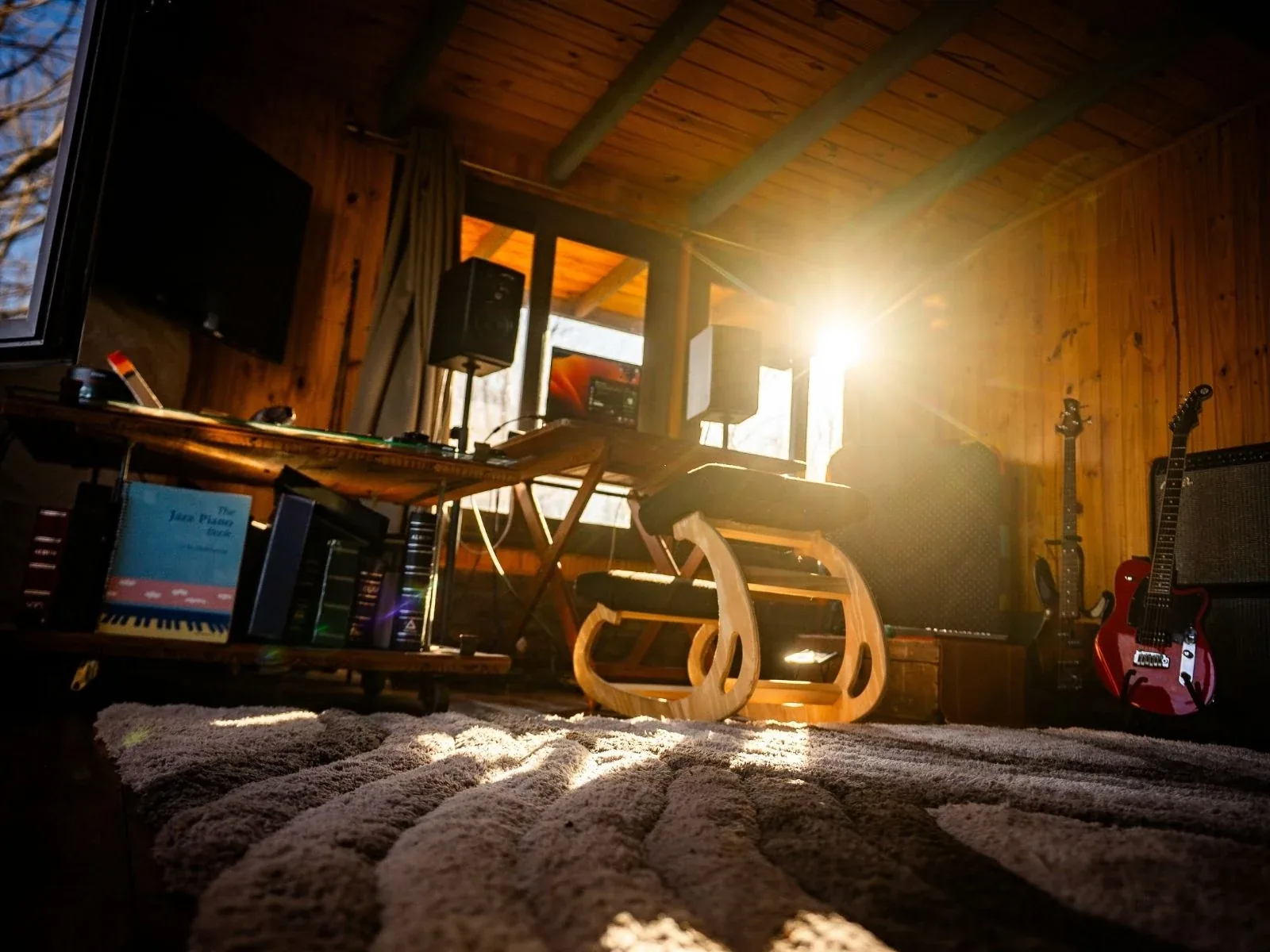 Interior del estudio Cauce con luz solar rasante y guitarra roja