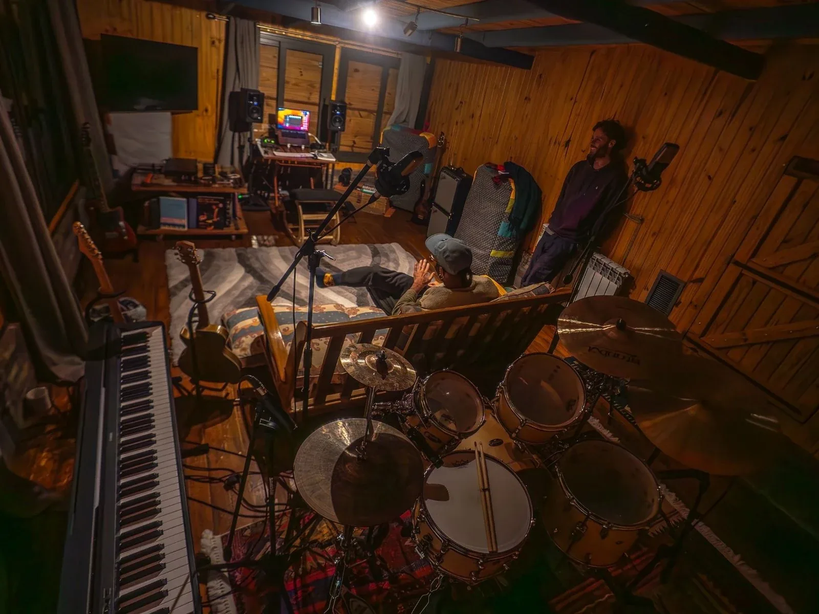 Vista nocturna del estudio desde arriba, piano y batería visibles