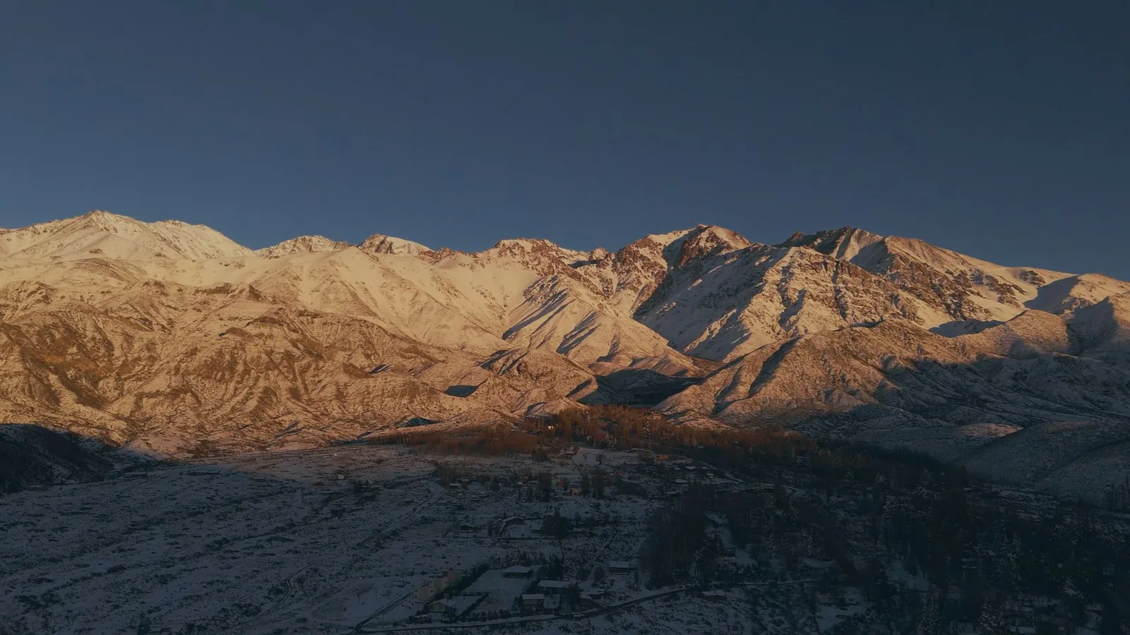 Cordillera de los Andes al atardecer, luz dorada sobre la nieve